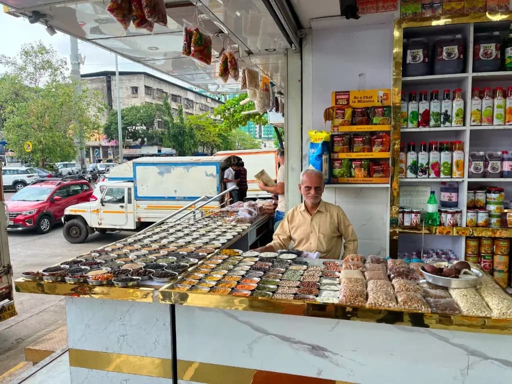 Jai Mahakal Traders staff displaying dry fruits and spices behind the counter